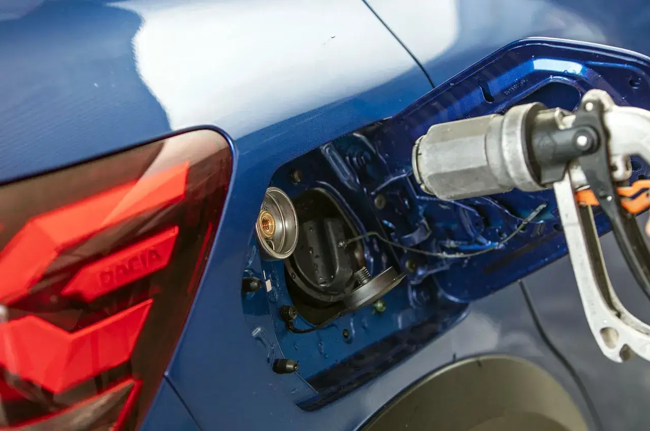 Tankowanie gazu LPG do niebieskiego samochodu Dacia.