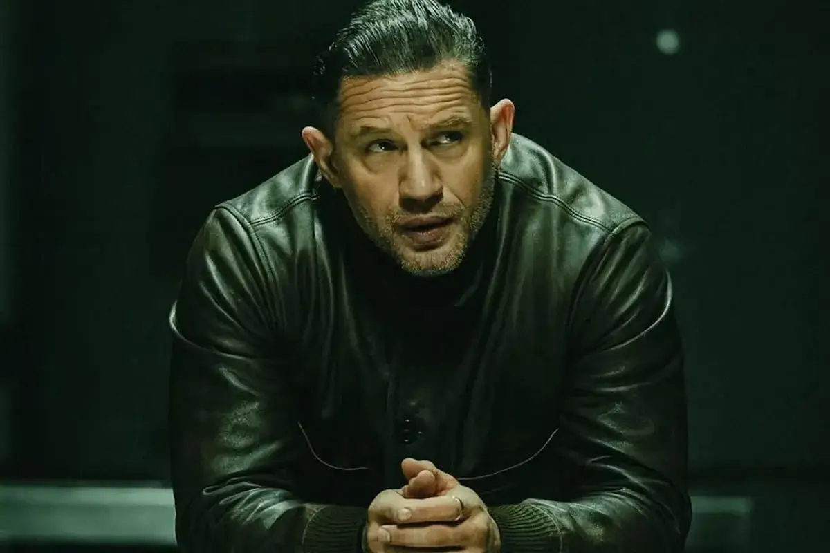 Tom Hardy w skórzanej kurtce, członek obsady "Strefy gangsterów", spogląda w bok z zamyśloną miną.