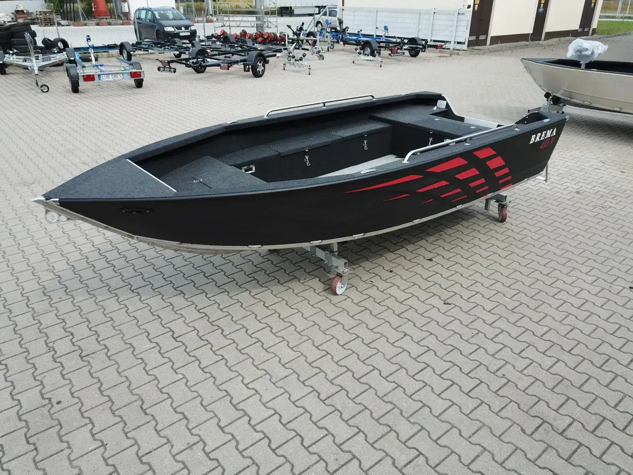 Czarna łódka wędkarska "BREMA 435V" na przyczepie. Czy łódkę wędkarską trzeba rejestrować? Zapytaj sprzedawcę.