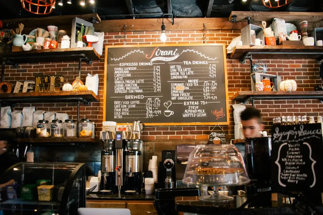 Pizarra con lista de precios de bebidas para bares, incluyendo cafés, tés y extras. ¡Una guía útil para la lista de precios de bebidas para bares 2026!