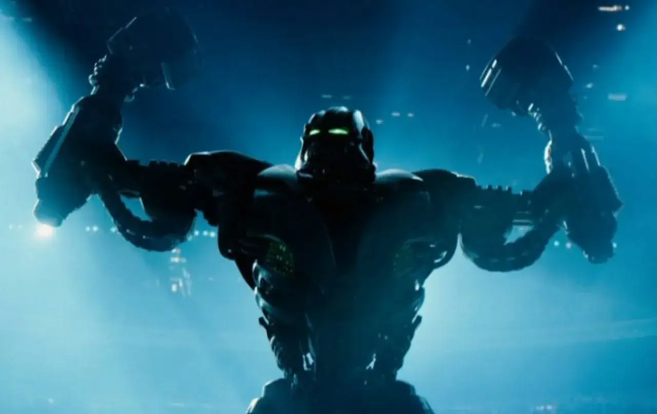 Giganci ze stali 2: potężny robot z zielonymi oczami wznosi ręce, gotowy do walki na arenie.