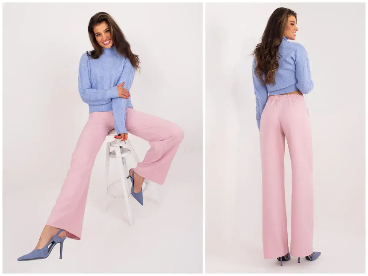 Modelka w granatowym sweterku i pudrowym różu spodniach prezentuje stylowe granat i pudrowy róż stylizacje.