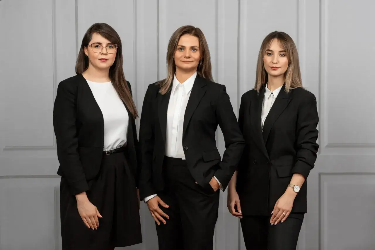 Trzy kobiety w czarnych garniturach. Zastanawiasz się, ile bierze adwokat za reprezentowanie w sądzie?
