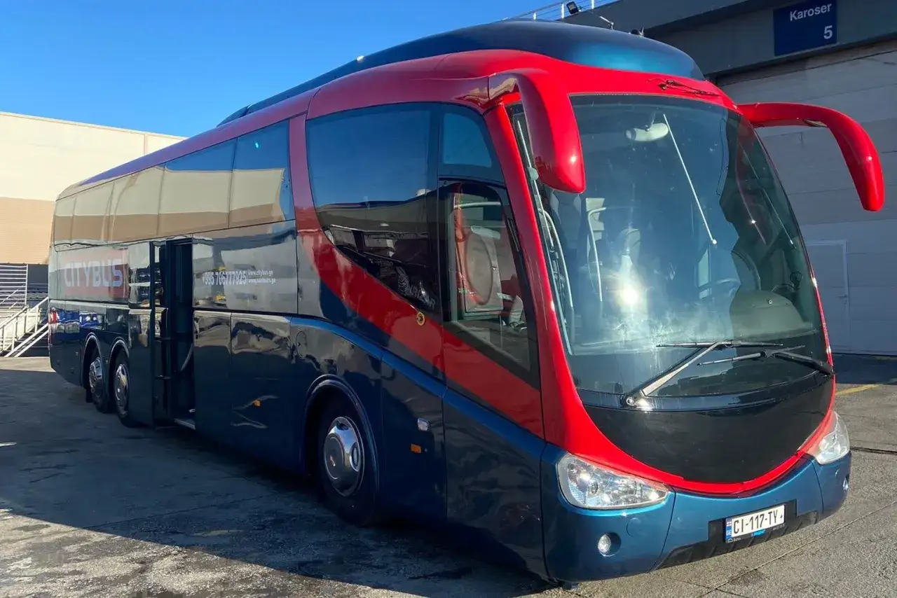 Autobus Citybus, idealny, by dowiedzieć się, jak dojechać z Kutaisi do Batumi. Czerwono-niebieski pojazd z otwartymi drzwiami.