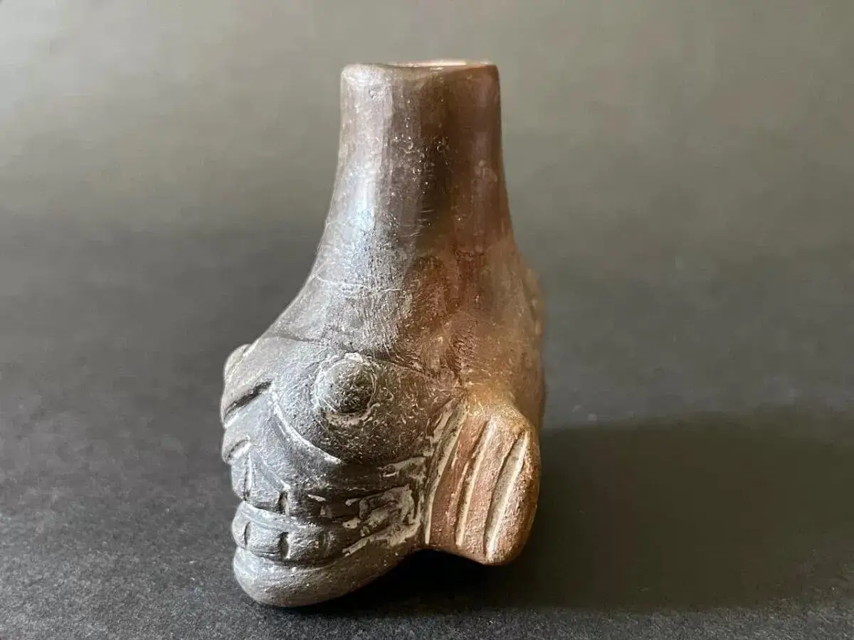 Mroczny aztecki gwizdek śmierci w kształcie ryby, z wyrazistymi oczami i zębami, wydaje przerażający dźwięk.