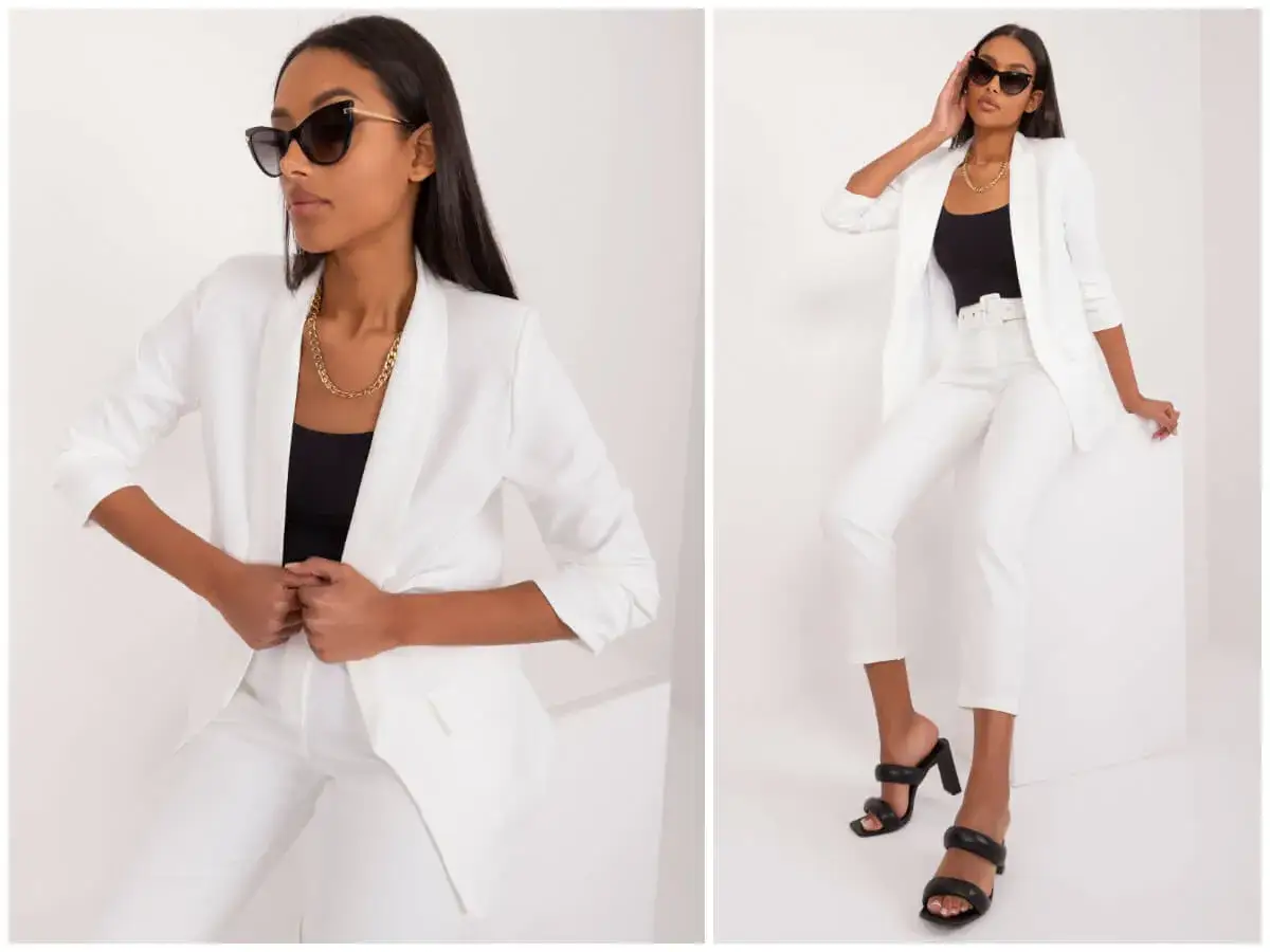 Elegancki biały żakiet w stylizacjach. Kobieta w białym garniturze i czarnym topie, uzupełnionym złotym łańcuszkiem i okularami.