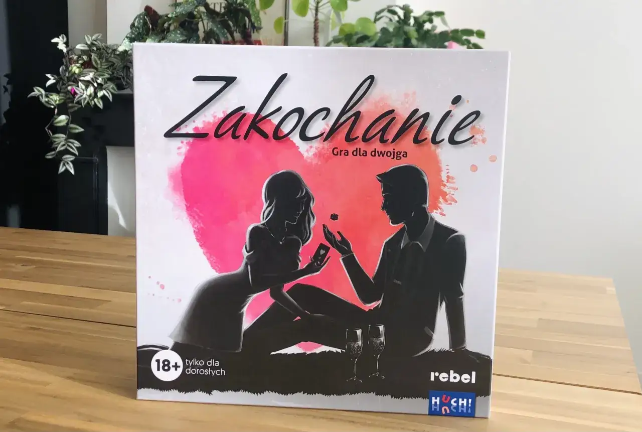 Zakochanie gra dla dwojga" - pudełko gry z sylwetkami pary, sercem i kieliszkami.