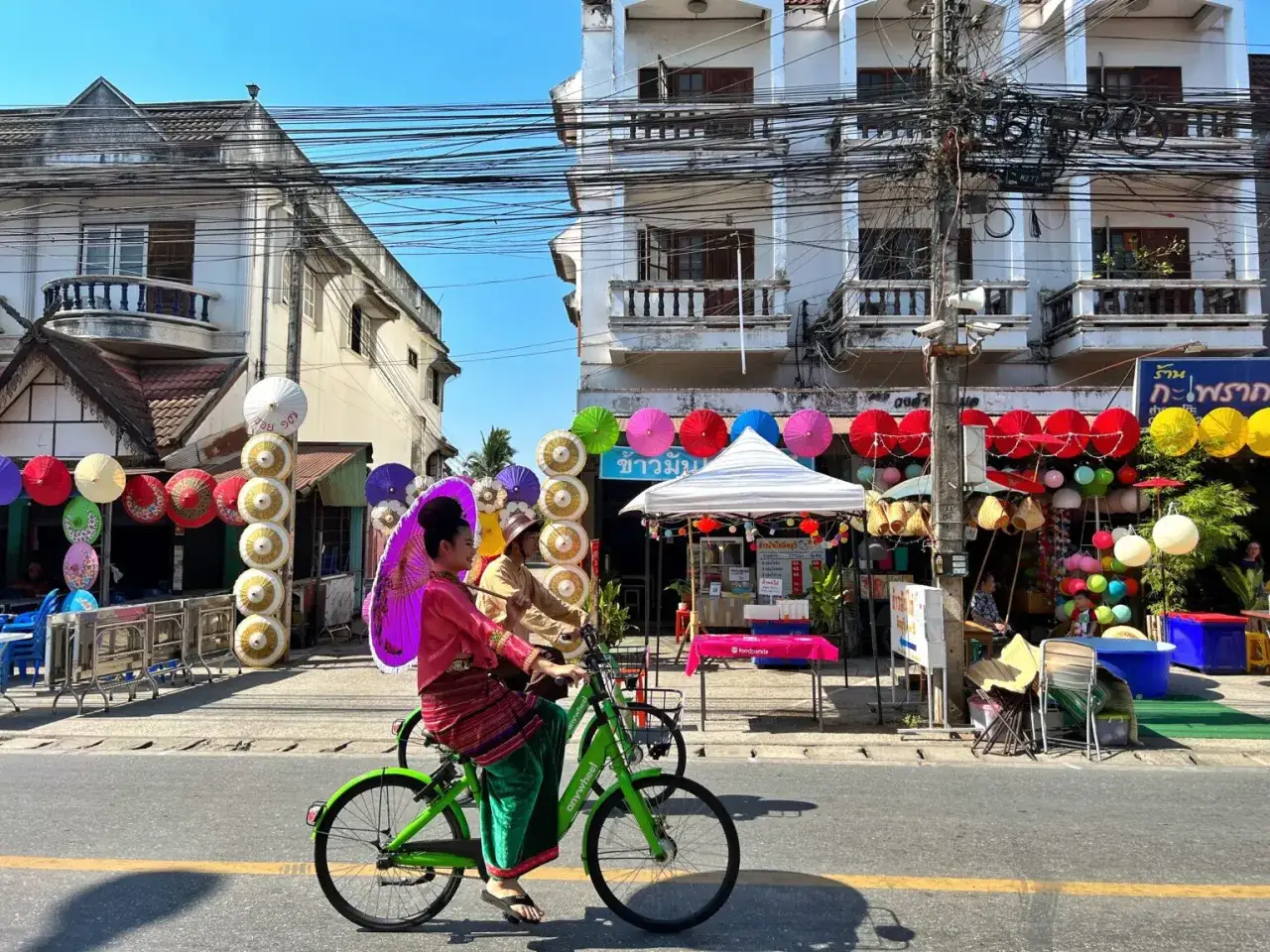 Kolorowe parasolki i tradycyjne stroje w Chiang Mai, gdzie nocować, tworzą festiwalową atmosferę.