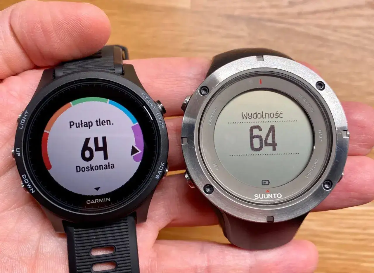 Porównanie zegarków sportowych: Garmin z kolorowym ekranem i pomiarem pułapu tlenowego oraz Suunto z monochromatycznym wyświetlaczem i wskaźnikiem wydolności.