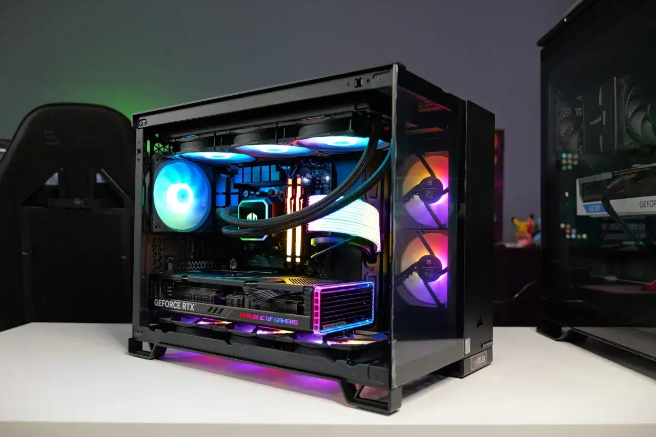 Wnętrze komputera z podświetlanymi wentylatorami i kartą graficzną GeForce RTX. Widać wiele części komputera, w tym chłodzenie procesora i pamięć RAM.
