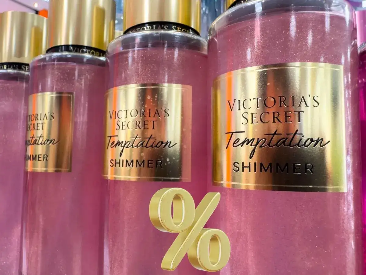 Różowe mgiełki Victoria's Secret Temptation Shimmer z złotymi etykietami i złotym symbolem procentu.