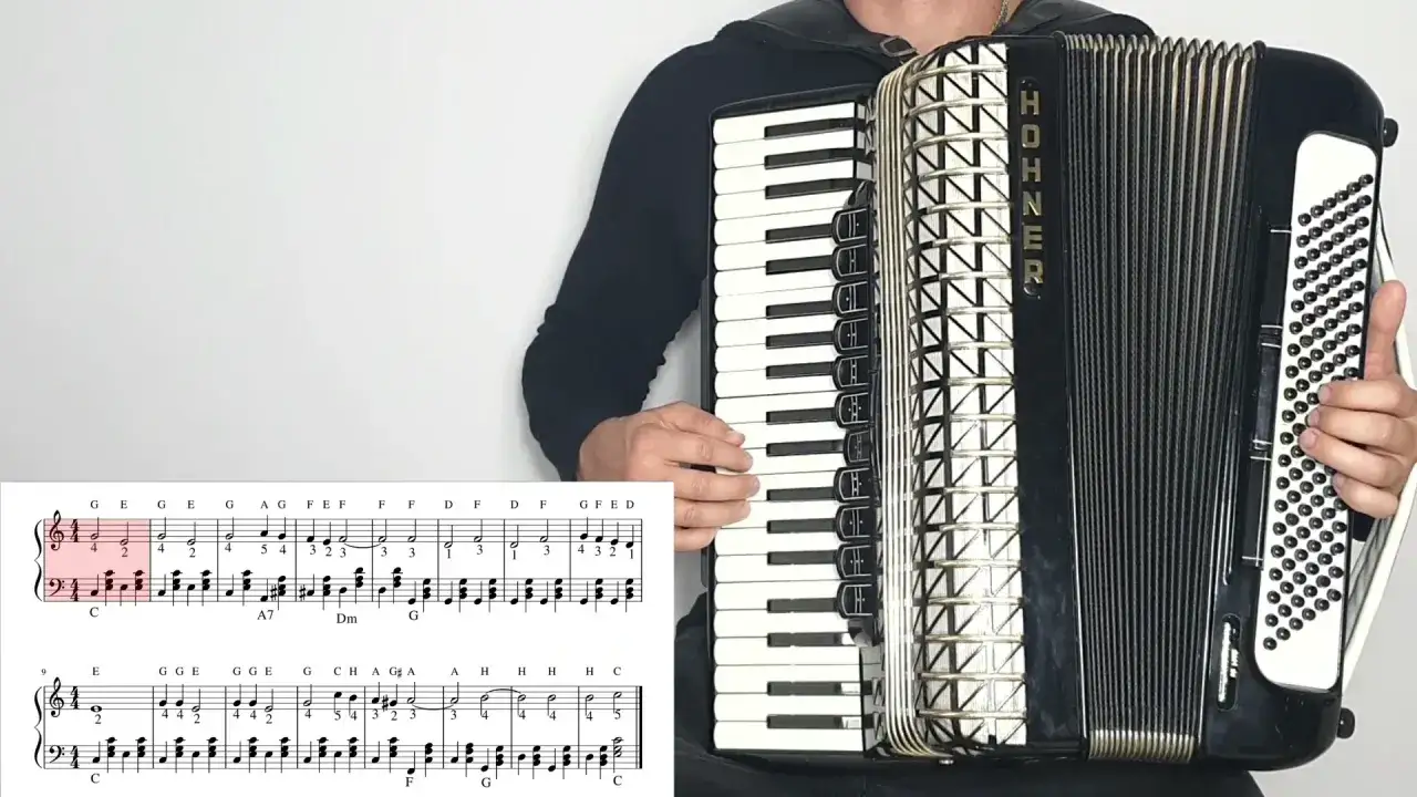 Akordeonista gra znane utwory na akordeon, widoczna partytura z nutami.