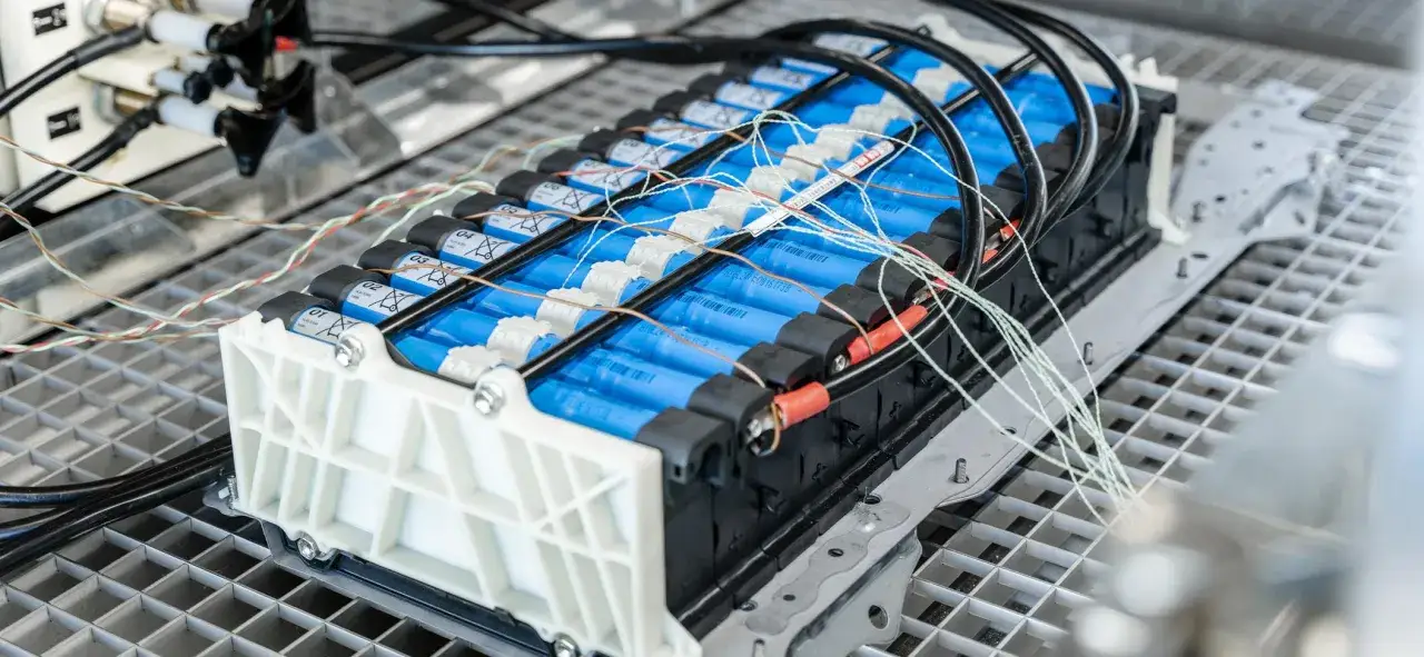 Baterie litowo-jonowe w samochodzie elektrycznym, z widocznymi przewodami i złączami, ilustrujące sposoby łączenia przewodów elektrycznych w samochodzie.