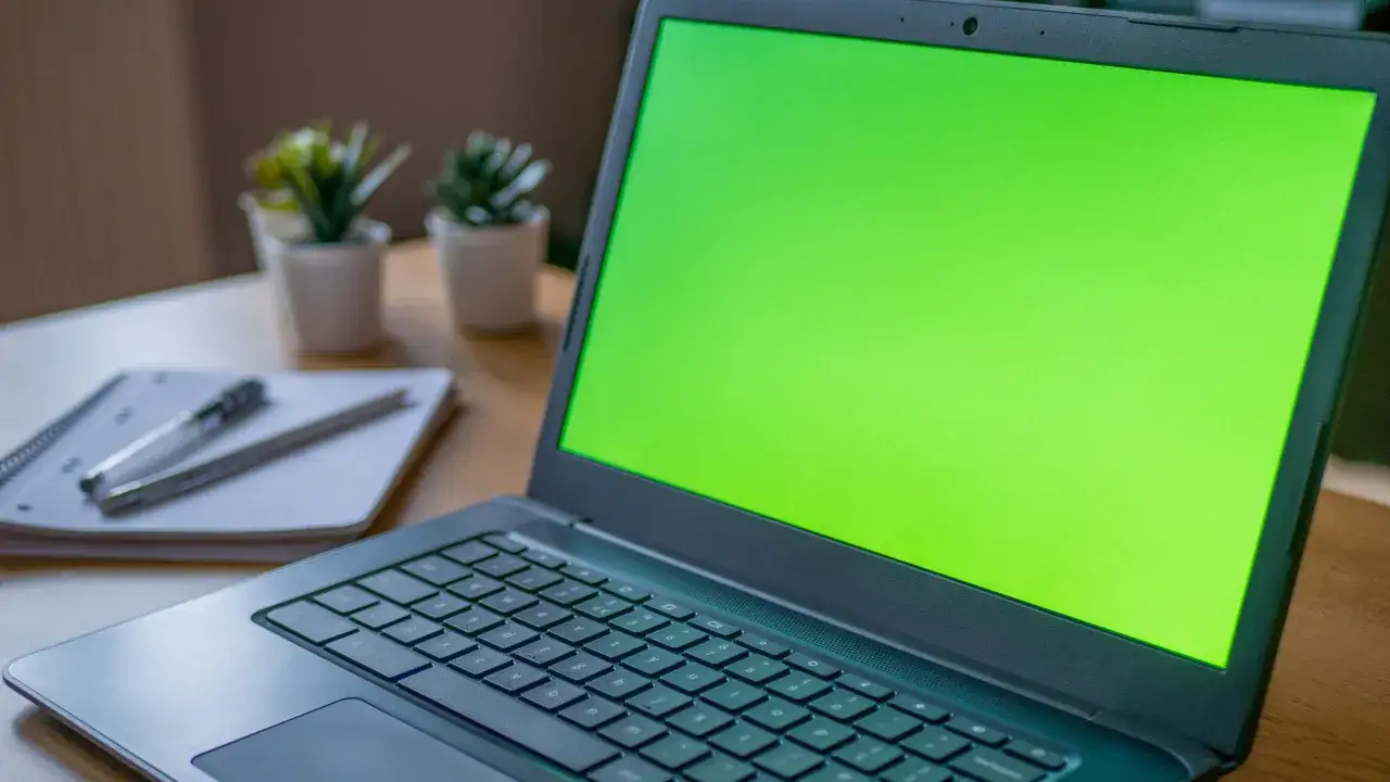 Zielony ekran laptopa, obok notatnik z długopisem. Czy to chromebook czy laptop?