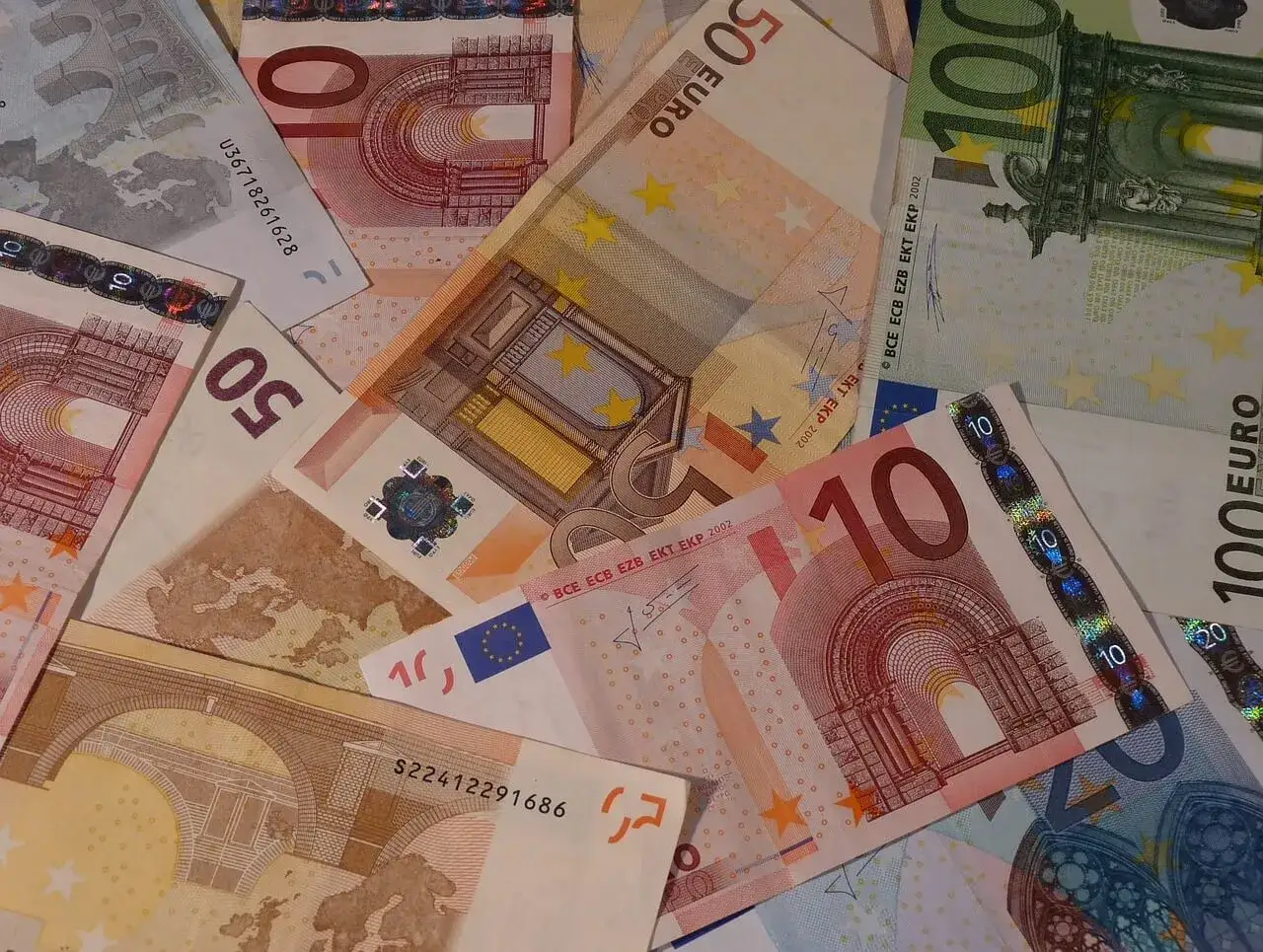 Stos banknotów euro o różnych nominałach: 10, 50 i 100 euro.