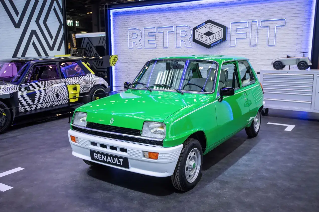 Zielony Renault 5 z napisem "RENAULT" na zderzaku. Obok niego futurystyczny model z czarno-białą grafiką. To przykład przerabiania aut na elektryczne.