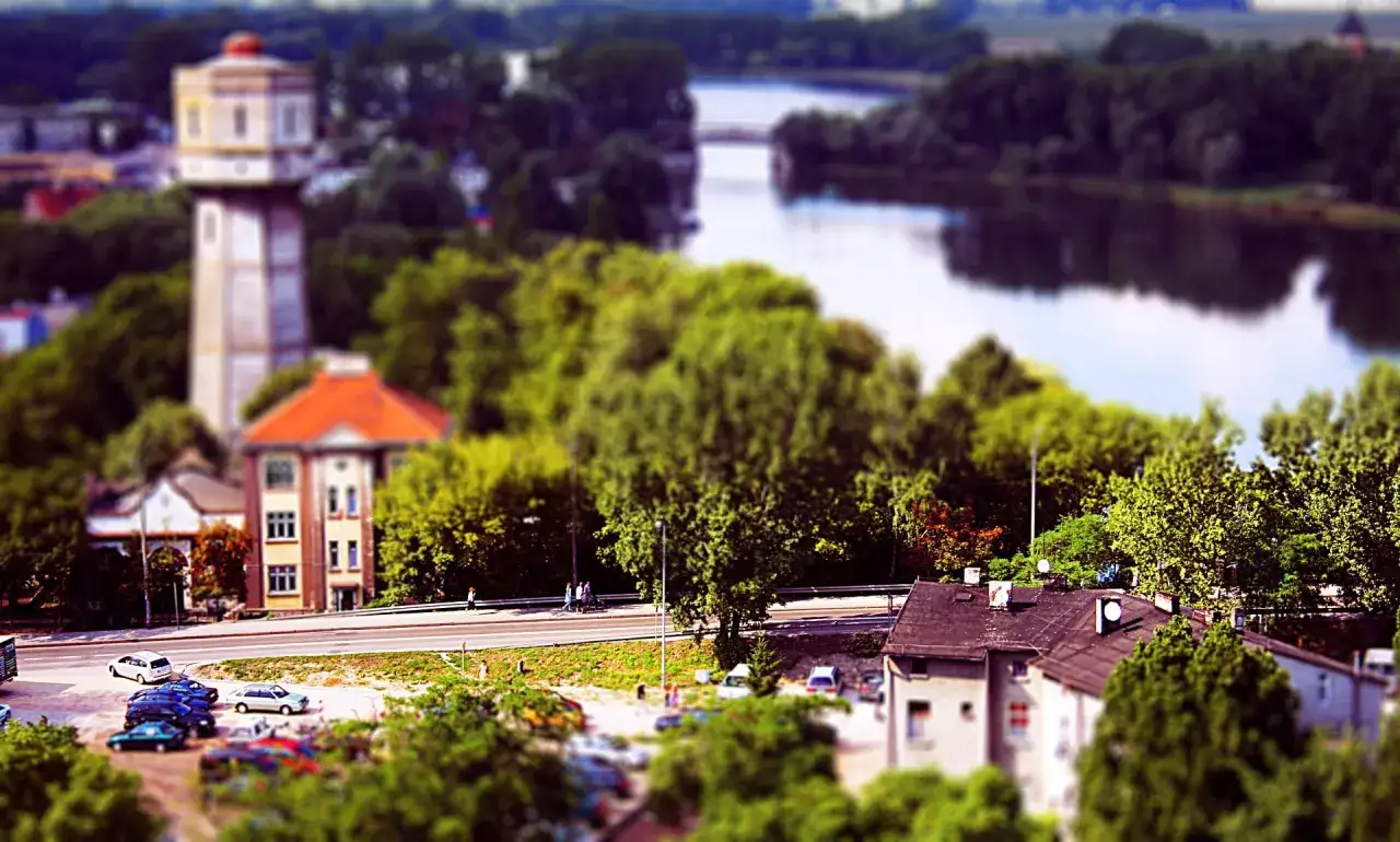 Widok na wieżę ciśnień, budynki i rzekę w Kruszwicy.
