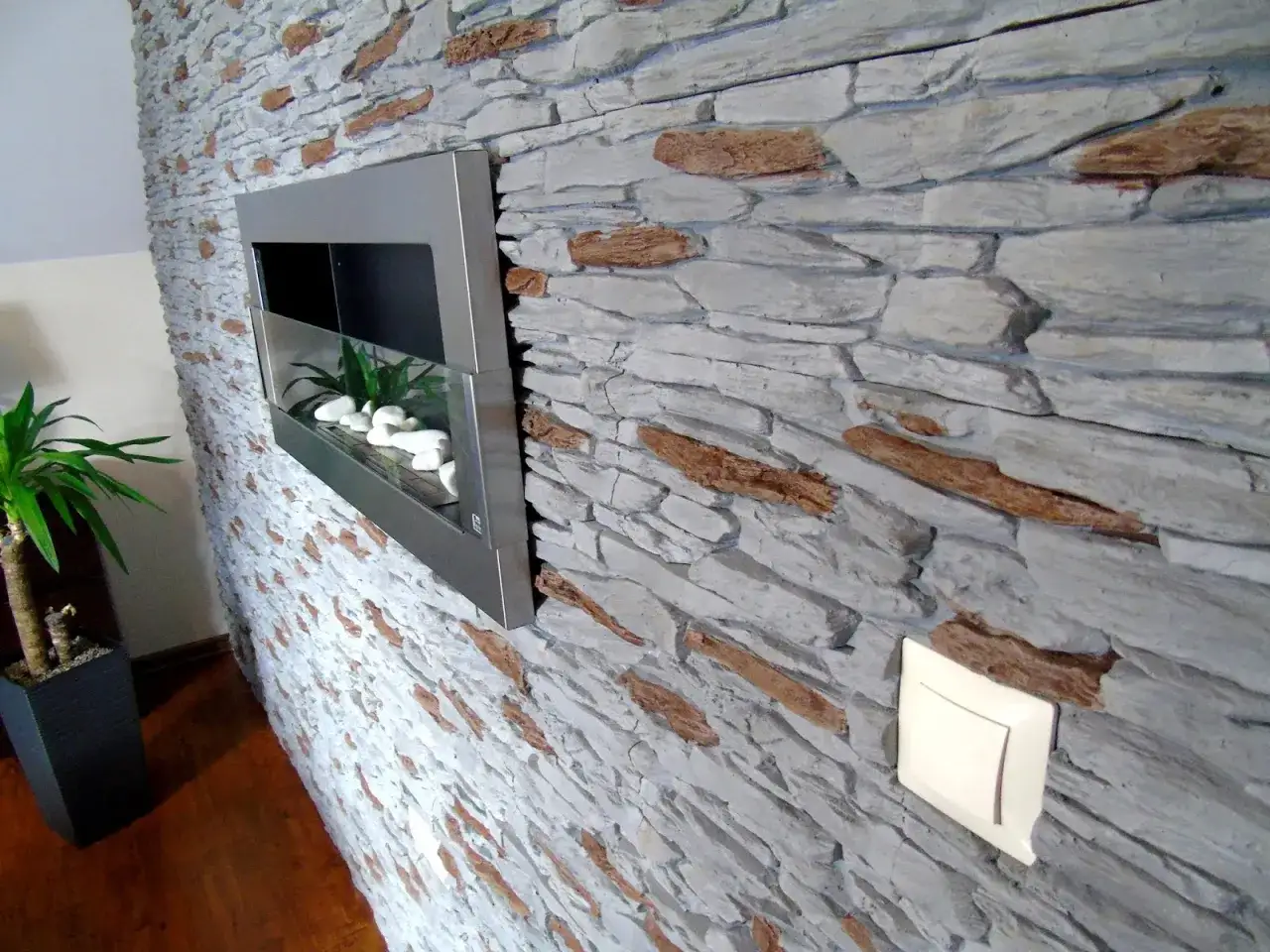 Nowoczesny kominek i gniazdko zamontowane w kamieniu dekoracyjnym. Jak zamontować gniazdka w kamieniu dekoracyjnym?