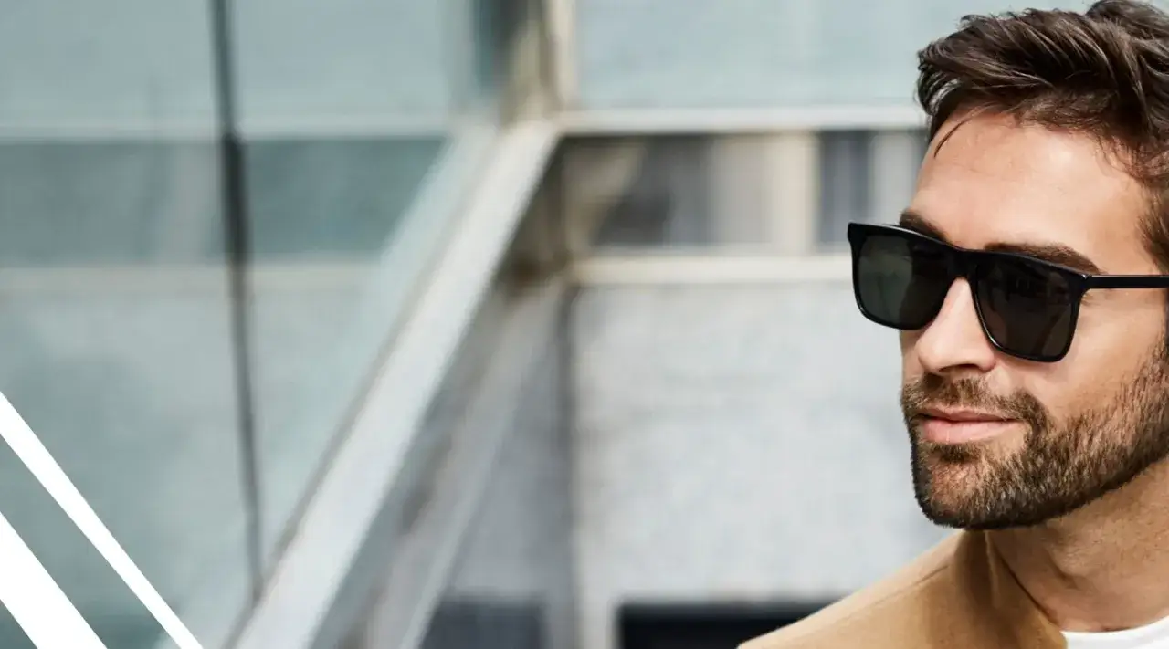 Mężczyzna w okularach przeciwsłonecznych z zarostem.