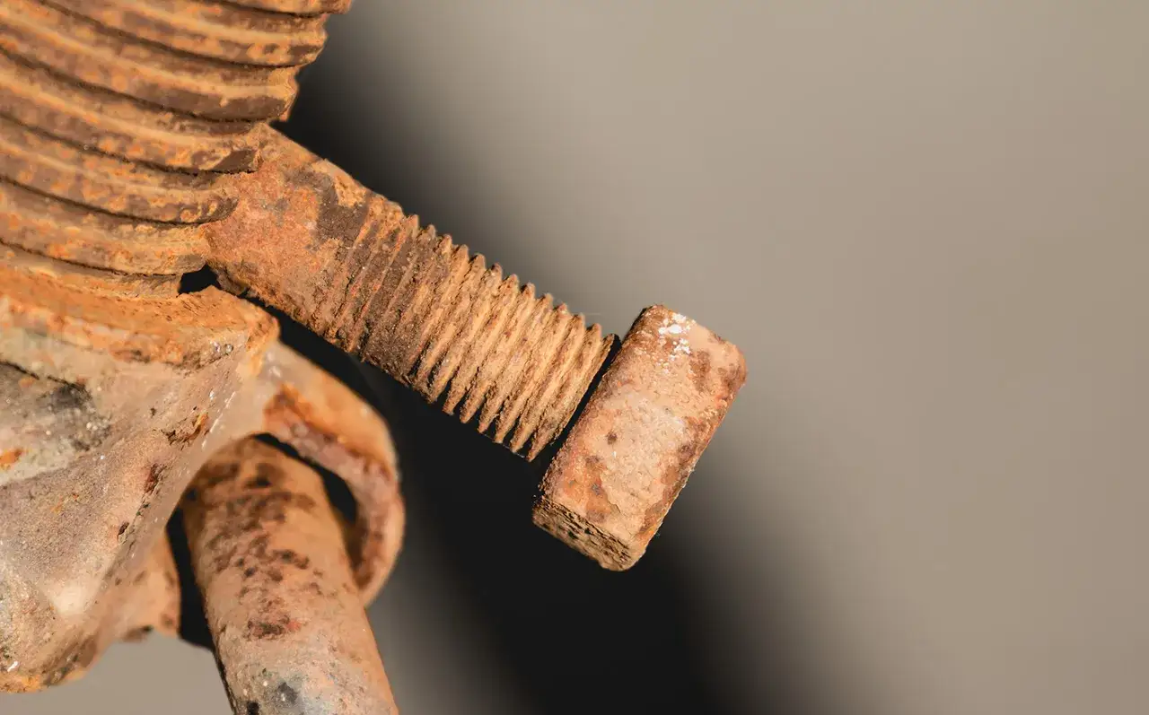 Zardzewiała śruba z gwintem. Aby ją odkręcić, należy ją przekręcić w lewo.