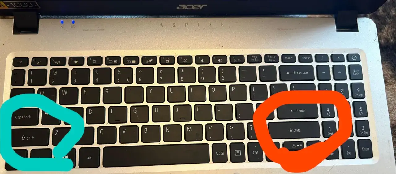 Klawisz Shift na klawiaturze laptopa Acer Aspire, zaznaczony na pomarańczowo, znajduje się pod klawiszem Enter.