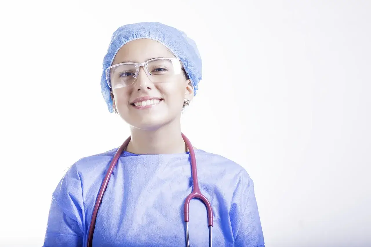Uśmiechnięta lekarka w czepku i okularach, z różowym stetoskopem. Szukasz najlepszych klinik medycyny estetycznej we Wrocławiu?