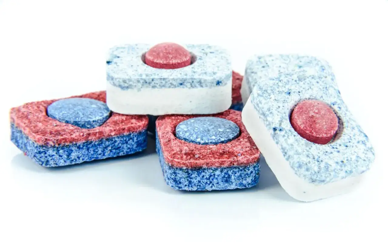 Tabletki do zmywarki w kolorach czerwonym i niebieskim, idealne do czyszczenia pralki.