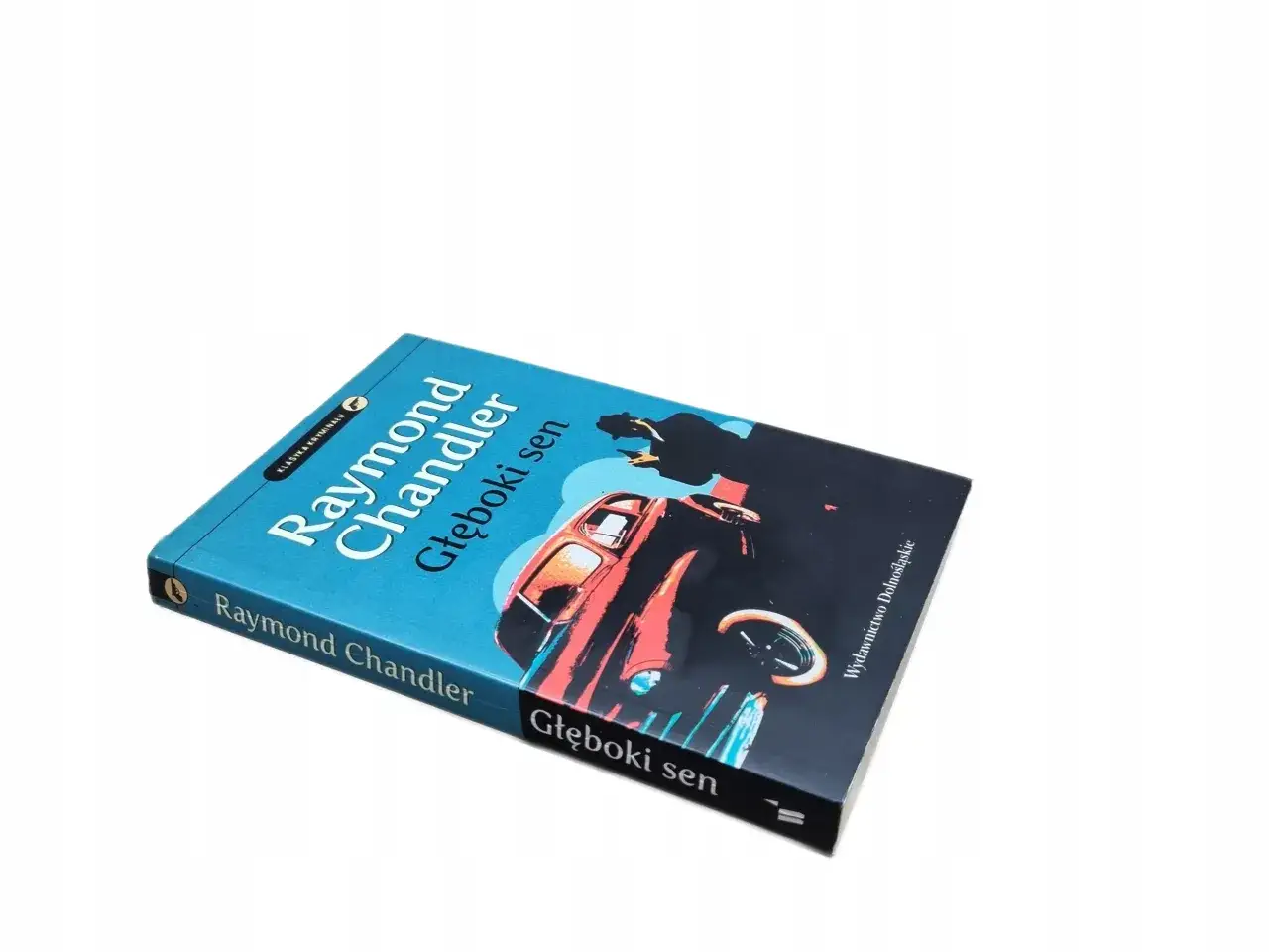 Okładka książki "Głęboki sen" Raymonda Chandlera z sylwetką i samochodem.