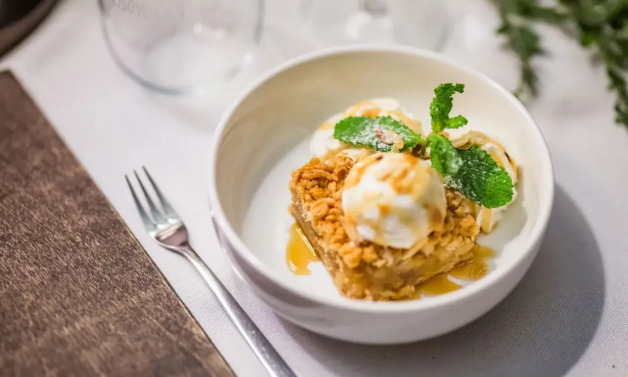 Pyszna szarlotka z lodami, polana syropem. Zastanawiasz się, ile kcal ma szarlotka z lodami? To deser idealny na deser!