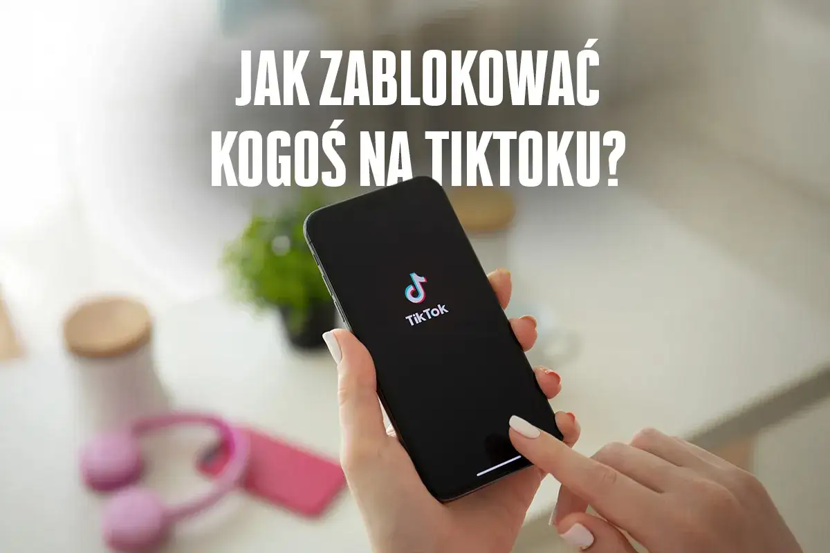 Dłoń trzyma smartfon z logo TikToka. Na ekranie telefonu widoczny jest napis "JAK ZABLOKOWAĆ KOGOŚ NA TIKTOKU?".