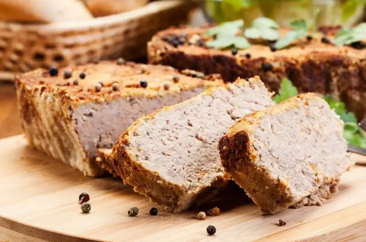 Pokrojony pasztet drobiowy z pieprzem na desce.