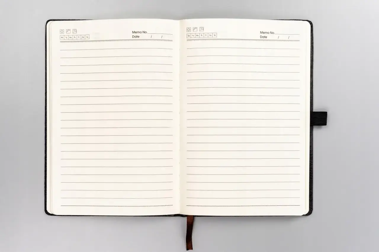 Otwarty notes z pustymi stronami w linie, gotowy na zapisanie ważnych myśli i notatek.