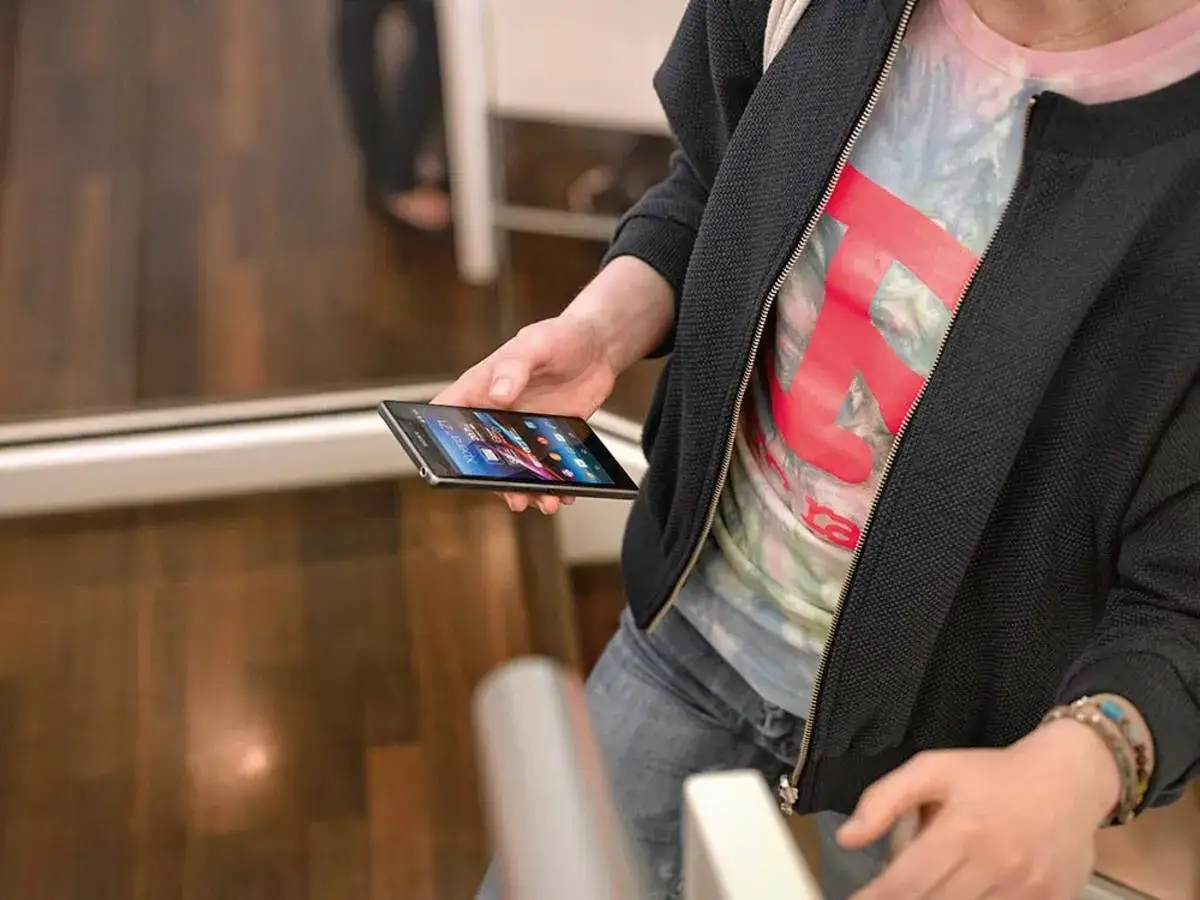 Osoba trzyma smartfon Samsung, na ekranie widać kolorowe ikony. Może właśnie robi nagrywanie ekranu Samsung.