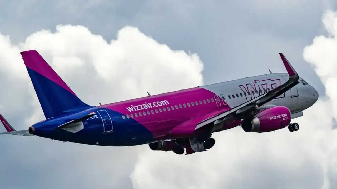 Samolot Wizzair wznosi się na tle chmur. To tanie linie lotnicze, które oferują loty po Europie.
