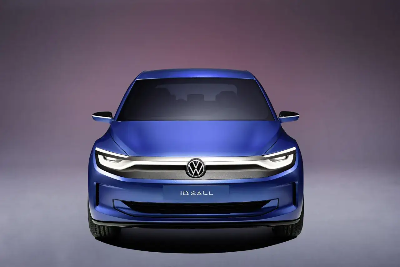 Niebieski Volkswagen ID.2ALL, jeden z nowych modeli marki, prezentuje futurystyczny design z charakterystycznym oświetleniem LED.