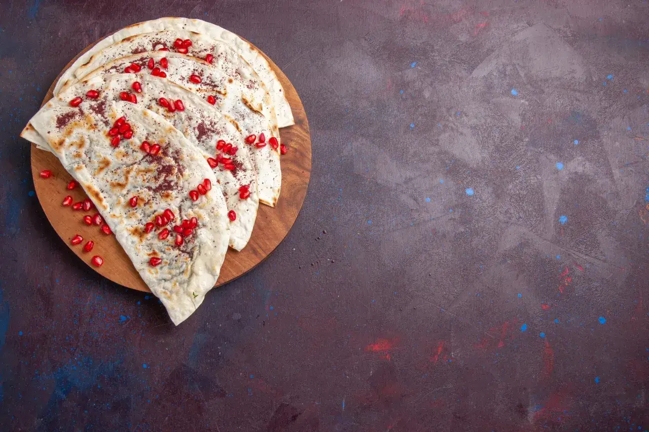 Plastry tortilli z granatem i przyprawami, idealne, by dowiedzieć się, jak podgrzać tortillę, żeby była miękka.