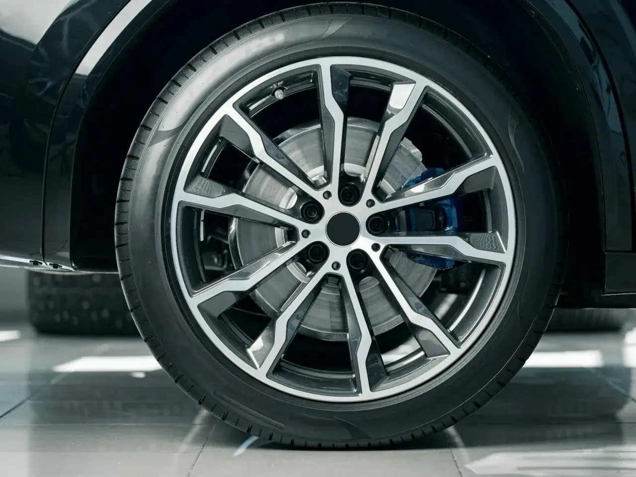 Nowoczesna, aluminiowa felga z niebieskim zaciskiem hamulcowym. Zastanawiasz się, czy można piaskować felgi aluminiowe?