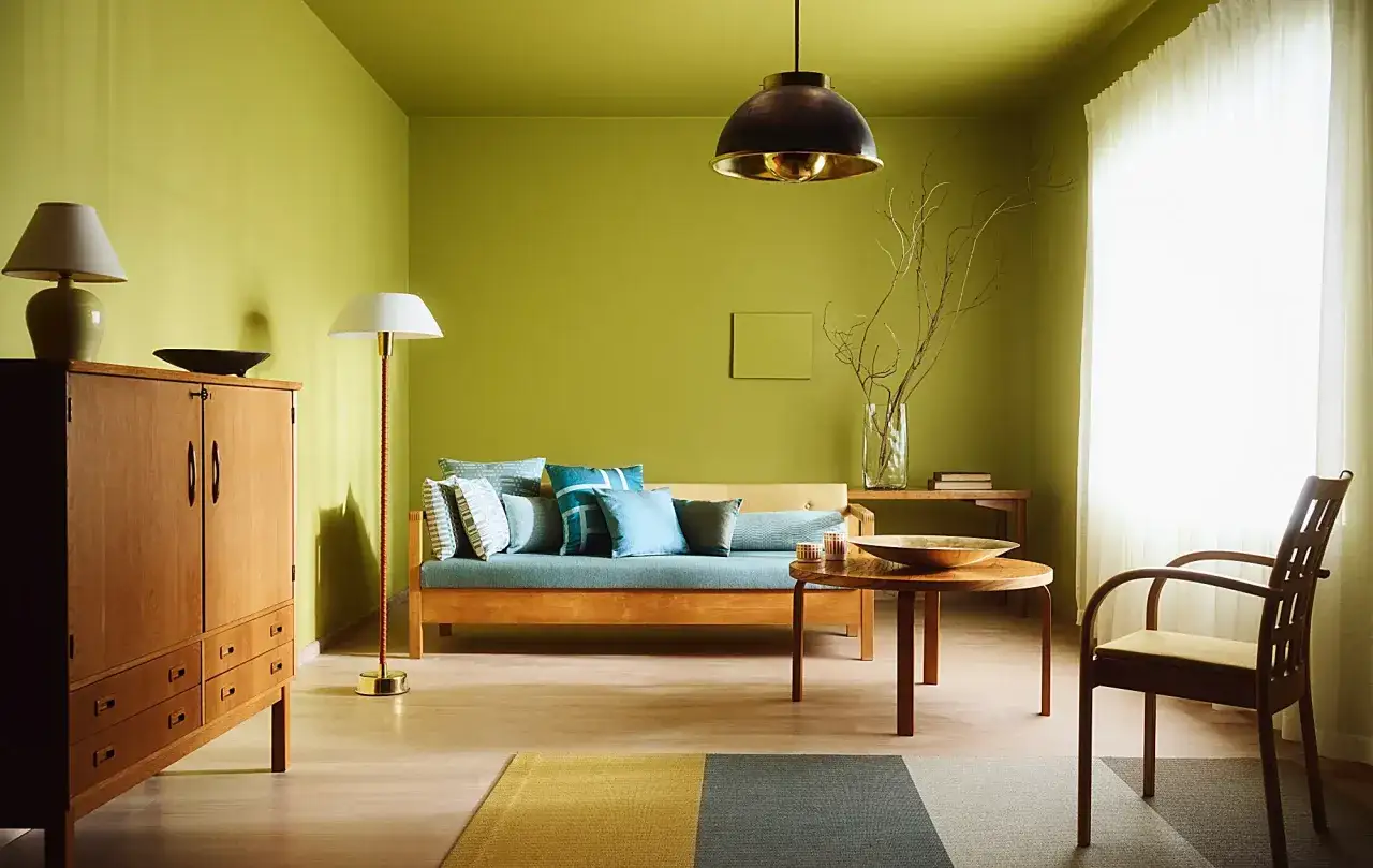 Zielone ściany i meble w stylu retro. Inspiracje do malowania ścian w salonie, tworzące przytulną atmosferę.