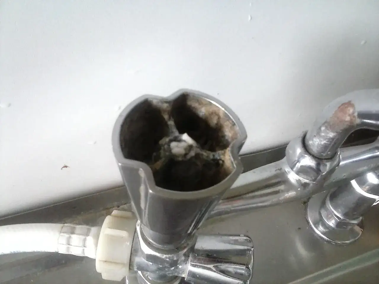 Zardzewiały kurek od kranu, z widocznym osadem. Jak odkręcić kurek od kranu, gdy jest zapieczony?