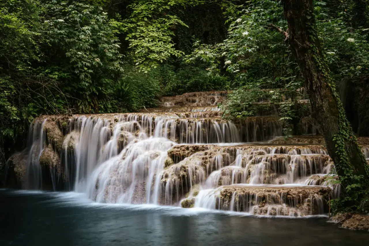 Wodospad w Zadarze, gdzie można odpocząć i podziwiać piękno natury. Woda spływa kaskadami po trawertynowych skałach, otoczona bujną zielenią.