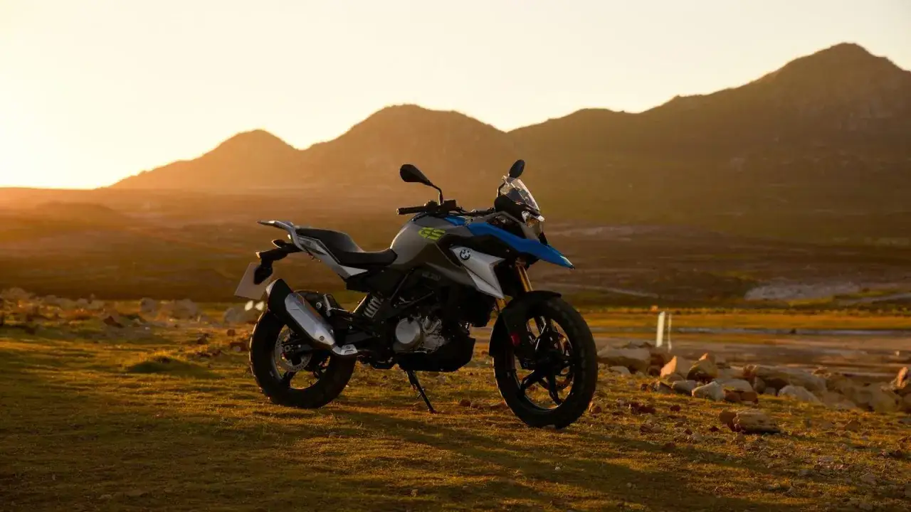 Motocykl BMW GS 310 na tle gór o zachodzie słońca.