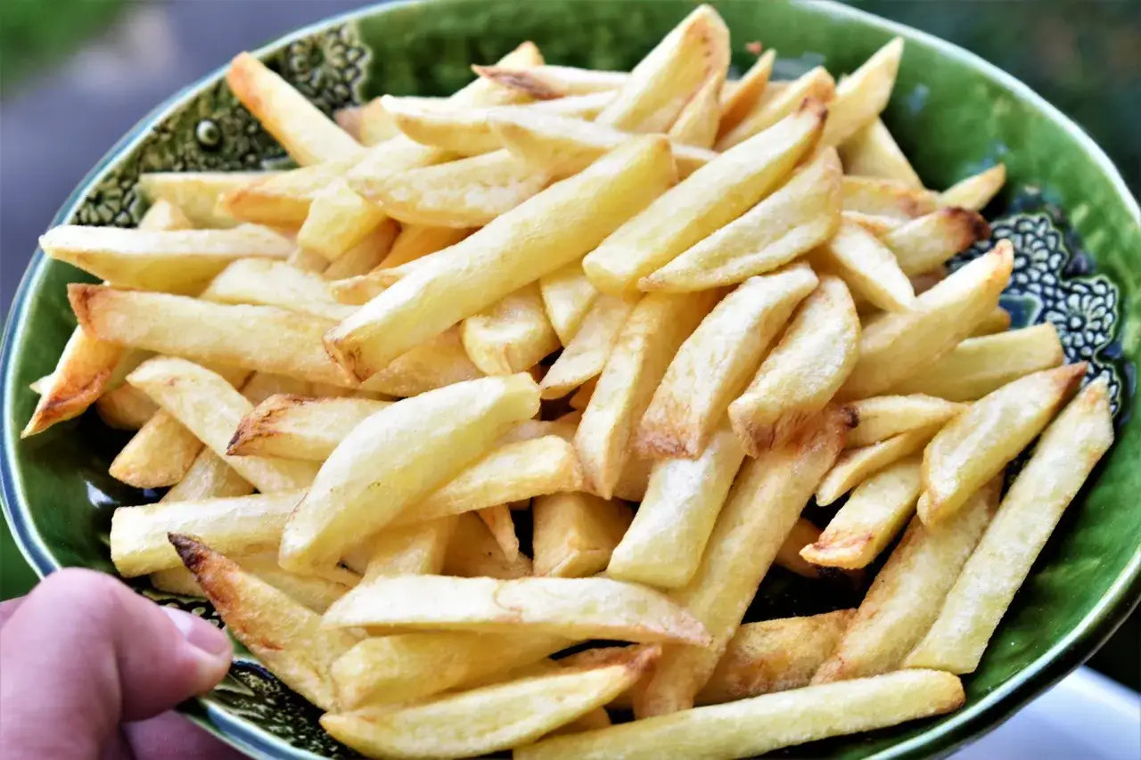 Złociste, chrupiące frytki stekowe w zielonej misce. Idealne do steka!