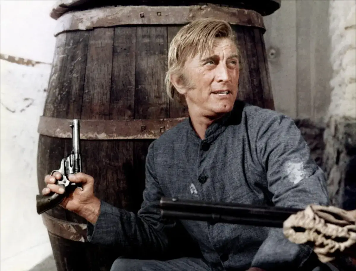 Kirk Douglas w westernowym filmie, z rewolwerem w dłoni, gotów do akcji.