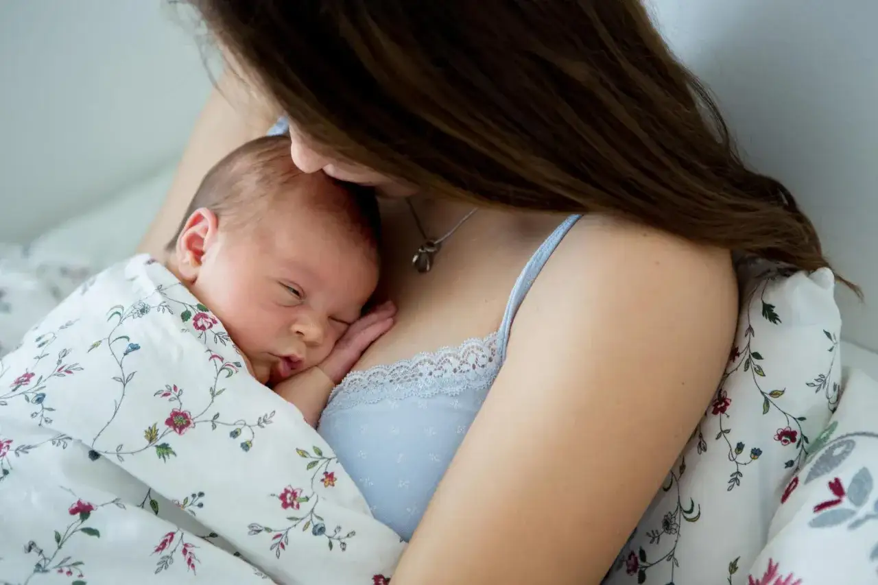 Matka tuli noworodka w ramionach, otulonego w kwiecisty kocyk.