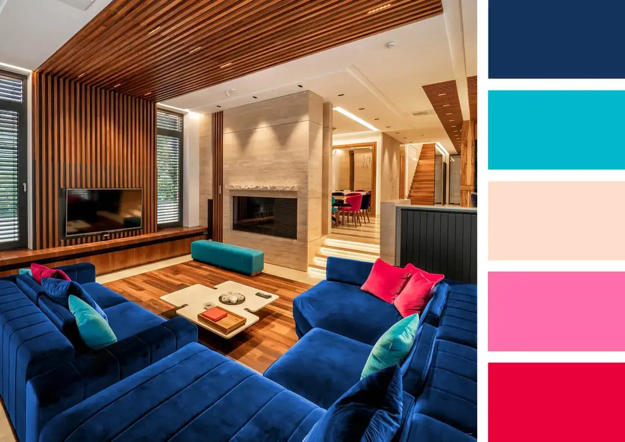 Nowoczesny salon z granatową kanapą. Jaki kolor pasuje do niebieskiego ciemnego? Jasny turkus, róż i beż tworzą odważną, ale harmonijną paletę.