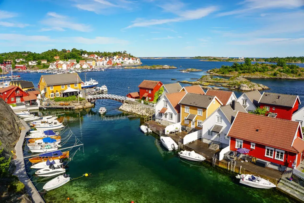 Malowniczy port z kolorowymi domkami i łodziami. Widok ten pokazuje, że Norwegia ma dostęp do morza, choć nie do Bałtyku.