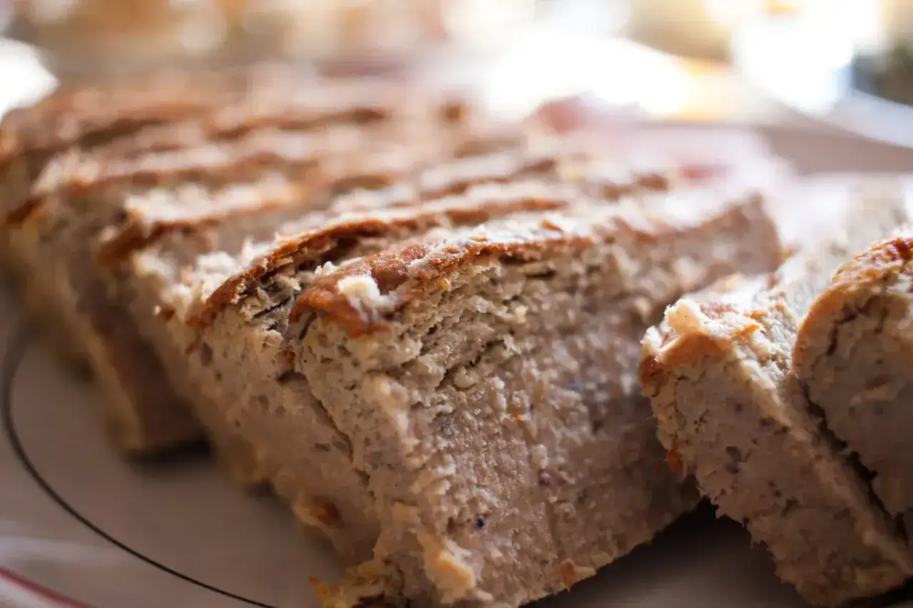 Pokrojony, domowy pasztet z chrupiącą skórką, na talerzu.