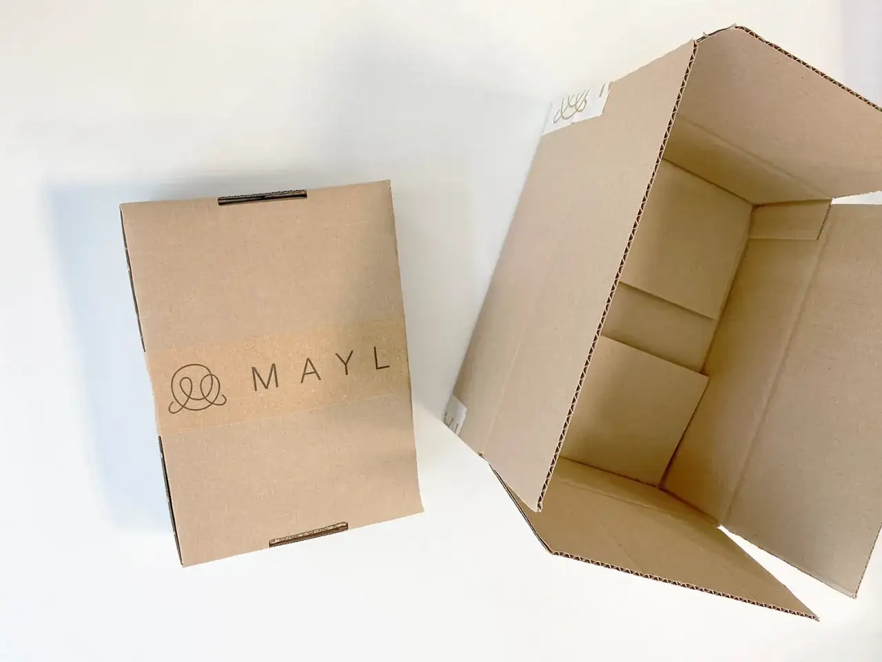 Dwa kartony, jeden zamknięty z logo MAYL, drugi otwarty. Pomyśl, co można zrobić z kartonu – to początek kreatywnych zabaw!
