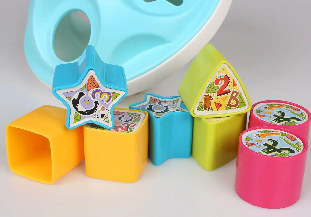 Kolorowe klocki i kształty do sortowania dla dzieci na jasnym tle.