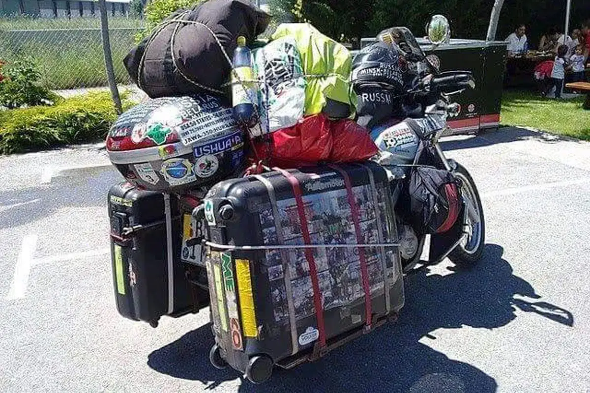 Motocykl z bagażami, gotowy na wyprawę. Widać walizki, torby i kask. To wszystko, co zabrać na wyprawę motocyklową.